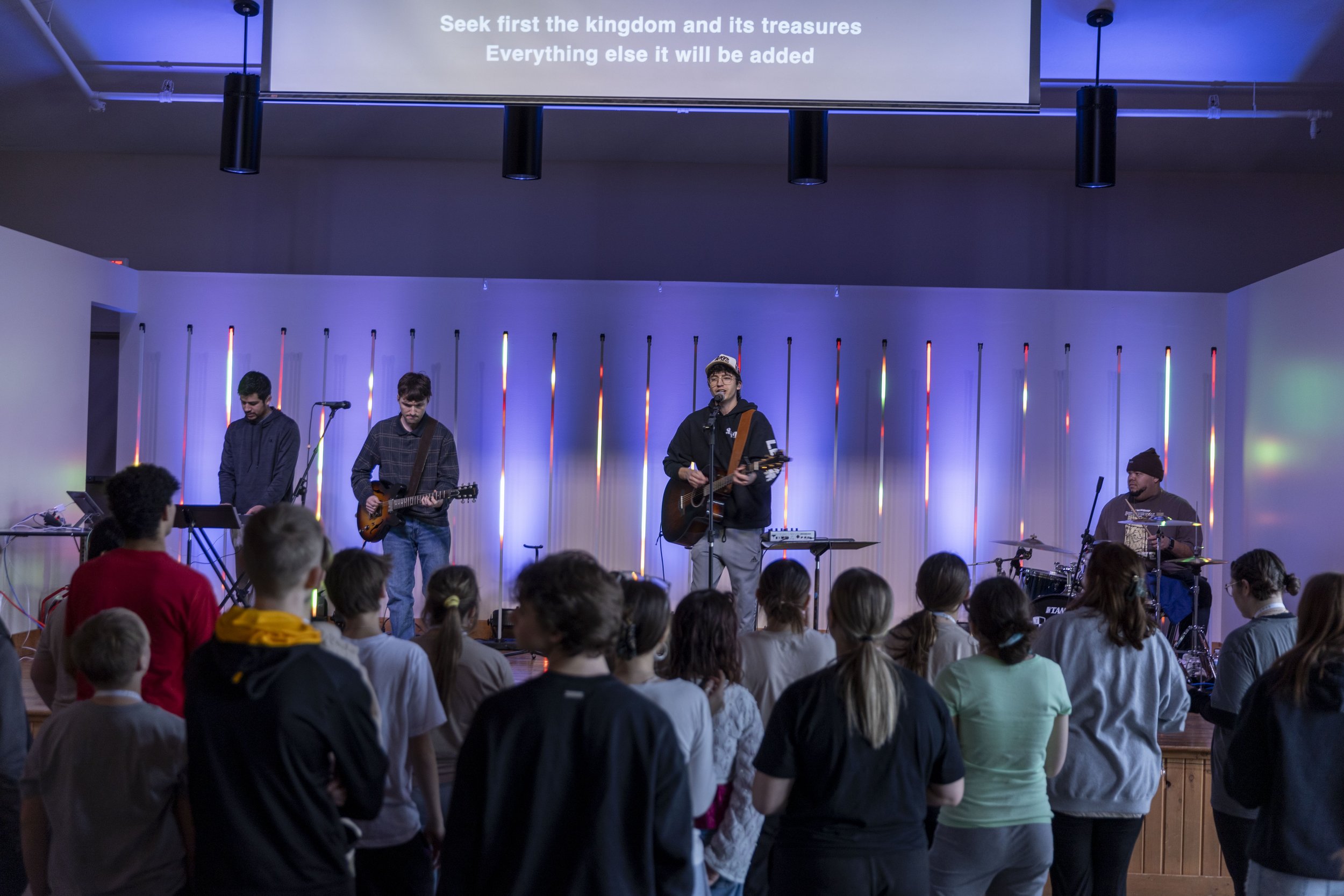 Worship night — pixel-mapped LED tube backdrop with a youth band on stage