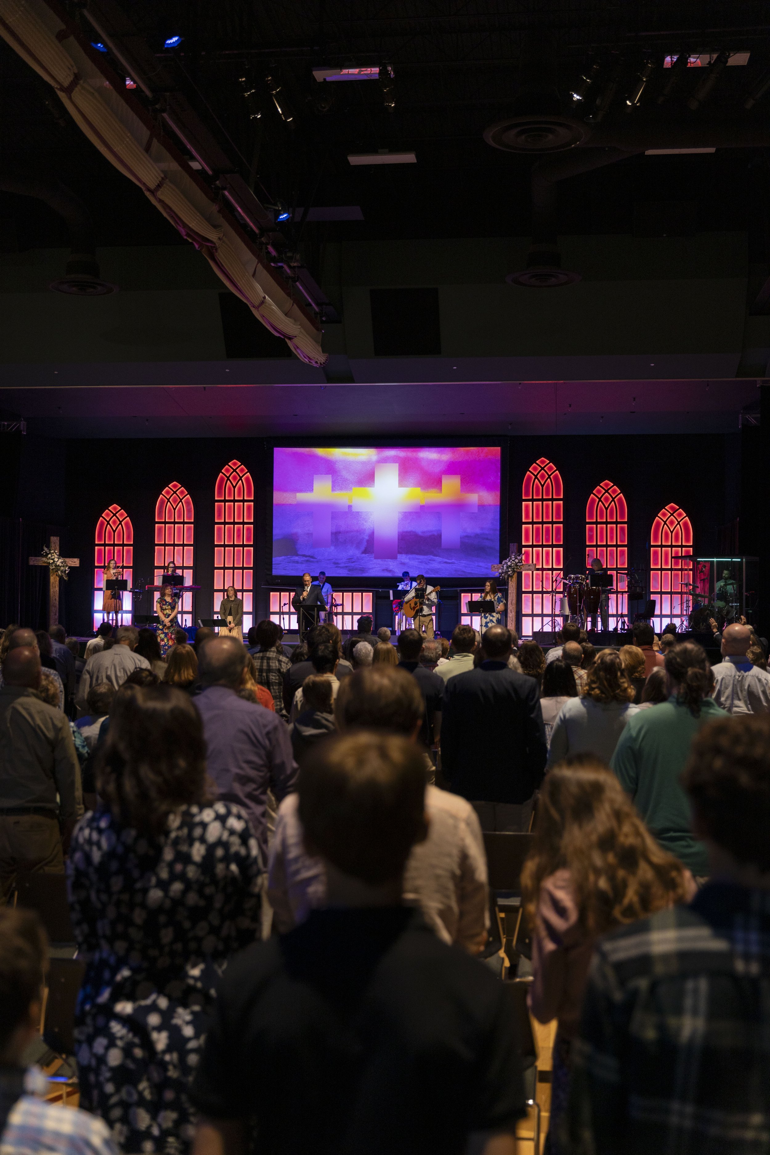 Sanctuary build — pink-toned stained-glass LED panels with cross motif on the screen